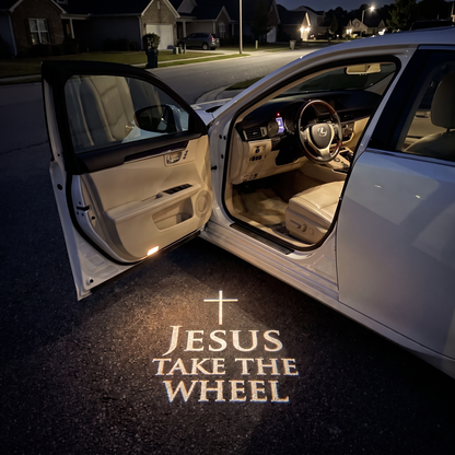 HaloDoor projecting Jesus Take the Wheel on the ground beside an open car door at night